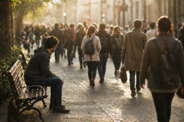 A person sitting alone on a bench while a crowd walks past without noticing, symbolizing content being ignored despite visibility
